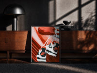 Black-framed Sneakers Hanging from a Car Mirror print on the floor in front of a dark wooden console