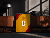 Black-framed FIFA World Cup 2026 Spain emblem print on a moody console with designer coffee-table books