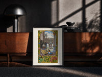 Black-framed Alchemist tending fire beneath fountain print on a moody console with designer coffee-table books