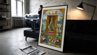 Peacock inside glass alchemical vessel print in a slim black frame leaning on a dark sofa in a concrete print studio