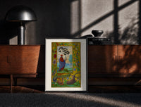 Black-framed Alchemist holding a flask print on a moody console with designer coffee-table books
