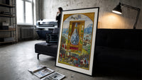 Crowned double-headed bird in flask print in a slim black frame leaning on a dark sofa in a concrete print studio