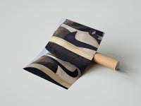 Gently curled Stacked Brown and Cream Sneakers print beside its protective shipping tube