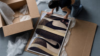 Stacked Brown and Cream Sneakers framed print being unpacked from protective bubble wrap and a box