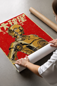 Woman unrolling the C-3PO Japanese retro poster on a concrete floor with cardboard tubes resting beside her