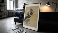Flamenco dancer with flowers in hair print in a slim black frame leaning on a dark sofa in a concrete print studio
