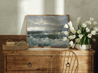 Crashing ocean waves on rocks print in an oak frame on a farmhouse dresser beside white tulips
