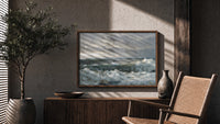 Crashing ocean waves on rocks print in a wood frame above a fluted sideboard beside an olive tree