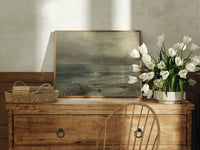 Stormy seascape with breaking waves print in an oak frame on a farmhouse dresser beside white tulips