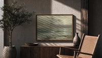 Stormy seascape with breaking waves print in a wood frame above a fluted sideboard beside an olive tree