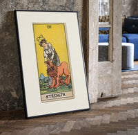 Woman taming a lion print in a black frame leaning beside a vintage door on parquet