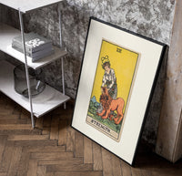 Woman taming a lion poster in a black frame leaning beside a shelf in a raw-plaster loft