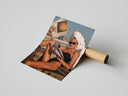 Sunbathing woman in black swimsuit with white towel on head reading newspaper, print unrolled beside shipping tube