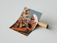 Sunbathing woman in a black swimsuit reads a newspaper, print unrolled beside a shipping tube