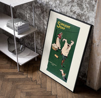 Boy playing with laundry, woman washing poster in a black frame leaning beside a shelf in a raw-plaster loft