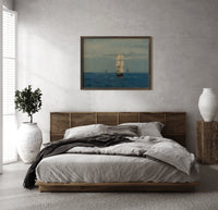 Tall sailing ship at sea print in a dark wood frame above a rattan bed on a plaster wall