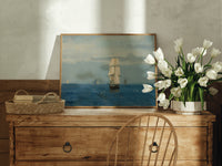 Tall sailing ship at sea print in an oak frame on a farmhouse dresser beside white tulips
