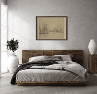 Sailing ships in a harbor print in a dark wood frame above a rattan bed on a plaster wall