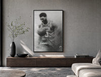 Basketball player celebrating with ball poster framed above a wood console in a concrete-wall living room