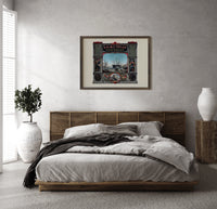 Victorian perfumers advertisement with harbor scene print in a dark wood frame above a rattan bed on a plaster wall