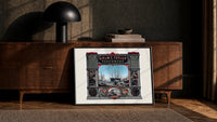 Victorian perfumers advertisement with harbor scene print in a black frame leaning against a walnut console in lamplight
