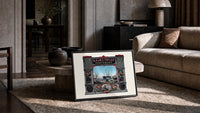 Victorian perfumers advertisement with harbor scene print in a slim black frame leaning on a travertine coffee table