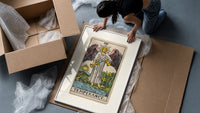 Winged angel pouring water between cups framed print being unpacked from protective bubble wrap and a box
