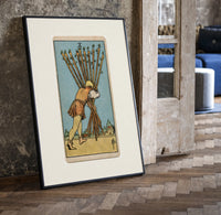 Man carrying ten wooden staves print in a black frame leaning beside a vintage door on parquet