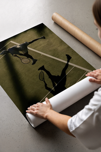 Person unrolling the tennis serve shadow poster flat across a grey concrete floor