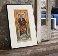 Bearded emperor on stone throne print in a black frame leaning beside a vintage door on parquet