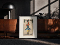 Black-framed Man hanging upside down from tree print on a moody console with designer coffee-table books