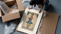 Man hanging upside down from tree framed print being unpacked from protective bubble wrap and a box
