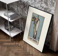 Cloaked hermit holding lantern and staff poster in a black frame leaning beside a shelf in a raw-plaster loft