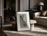 Cloaked hermit holding lantern and staff print in a black frame leaning on a travertine table in a sunlit lounge