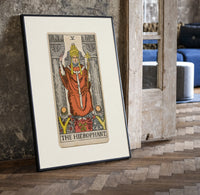 The Hierophant tarot figure on throne print in a black frame leaning beside a vintage door on parquet