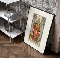 The Hierophant tarot figure on throne poster in a black frame leaning beside a shelf in a raw-plaster loft