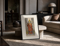 The Hierophant tarot figure on throne print in a black frame leaning on a travertine table in a sunlit lounge