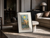The Star tarot card figure print in a black frame leaning on a travertine table in a sunlit lounge