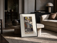 The Tower tarot card print in a black frame leaning on a travertine table in a sunlit lounge