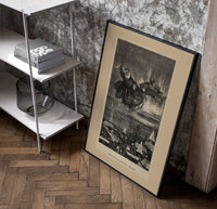Santa Claus in reindeer sleigh over rooftops poster in a black frame leaning beside a shelf in a raw-plaster loft