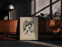 Black-framed Child praying beside bed at Christmas print on a moody console with designer coffee-table books