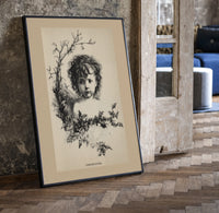 Curly-haired child's head with holly wreath print in a black frame leaning beside a vintage door on parquet