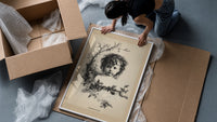 Curly-haired child's head with holly wreath framed print being unpacked from protective bubble wrap and a box