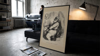 Santa Claus playing a piano print in a slim black frame leaning on a dark sofa in a concrete print studio