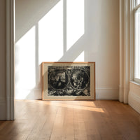 Praying woman and soldier at campfire print in an oak frame on a sunlit wood floor beneath tall window light