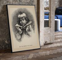 Child's face as Christmas plum pudding print in a black frame leaning beside a vintage door on parquet