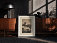 Black-framed Santa Claus in sleigh on rooftop print on a moody console with designer coffee-table books