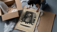 Child holding mistletoe in doorway framed print being unpacked from protective bubble wrap and a box