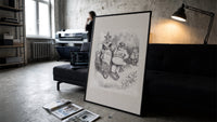 Santa Claus seated with Mother Goose print in a slim black frame leaning on a dark sofa in a concrete print studio