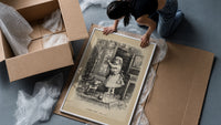Small child reaching toward nursery wall tiles framed print being unpacked from protective bubble wrap and a box